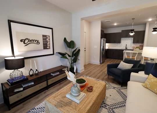 Modern living room with open kitchen and dark cabinetry at The Crest at South Point Apartments, Georgia, 30253