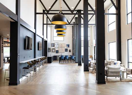 Community clubhouse with high ceilings and modern lighting at The Crest at South Point Apartments, Georgia