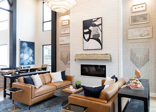 Two story lounge with fireplace and leather seating at The Crest at South Point Apartments, McDonough, GA 30253