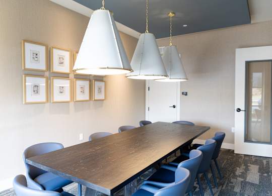 Conference room with large table and upholstered chairs at The Crest at South Point Apartments, McDonough, GA 30253