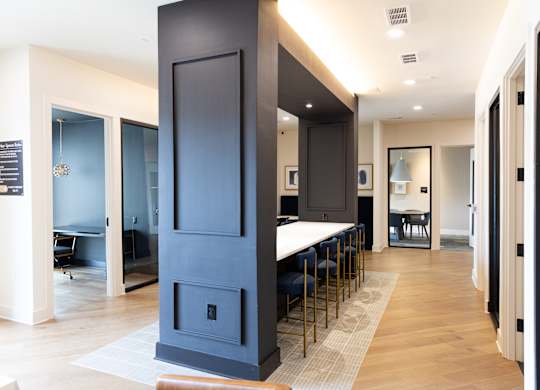 Community workspace with kitchen bar and bar stools at The Crest at South Point Apartments, McDonough, 30253