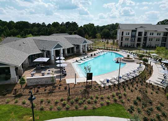 Resort style swimming pool with sun deck and lounge chairs at The Crest at South Point Apartments, McDonough