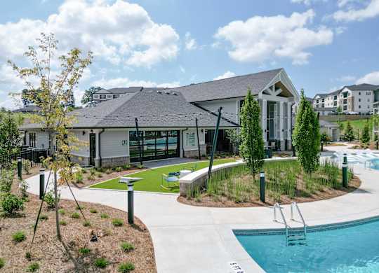 A pool area with a building in the background. at The Crest at Oakwood Apartments, Oakwood