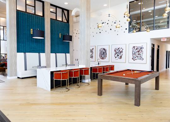 A room with a pool table and a shelf with artwork.
