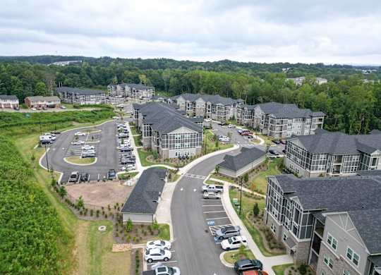 Aerial view of the rear apartment buildings, roads and parking areas at The Crest at Oakwood in Oakwood, GA.