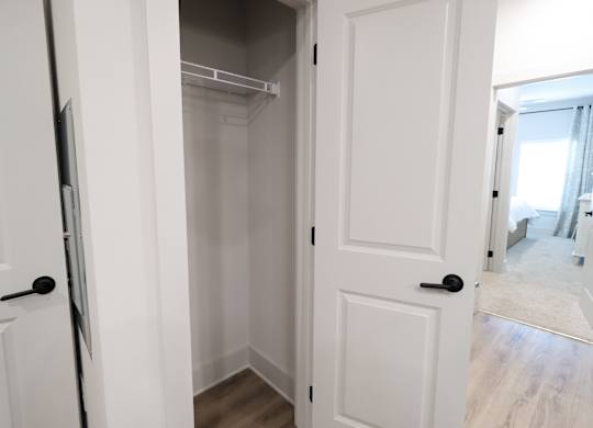 Empty walk-in closet with wire shelving and hanging rod at The Crest at South Point Apartments, McDonough, GA