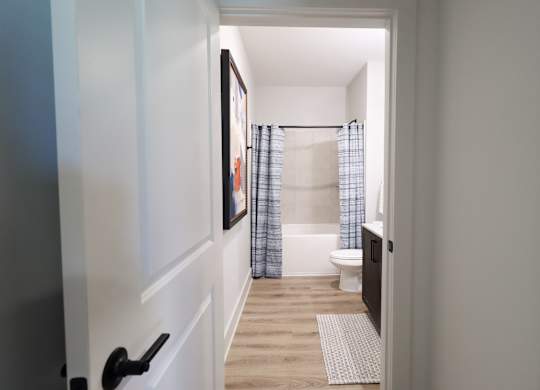 Bathroom with wood style flooring and toilet at The Crest at South Point Apartments, McDonough