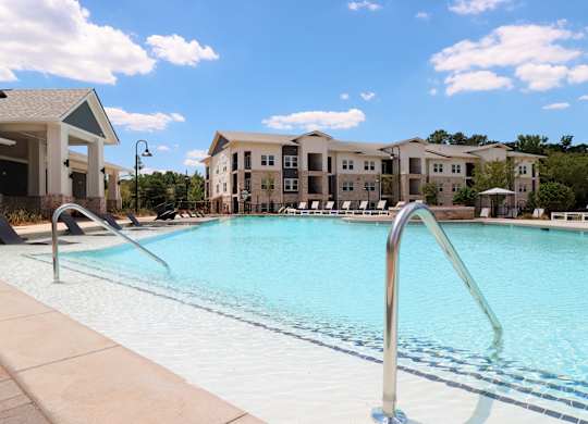 Large resort style pool with tanning shelf and cabana at The Crest at South Point Apartments, Georgia