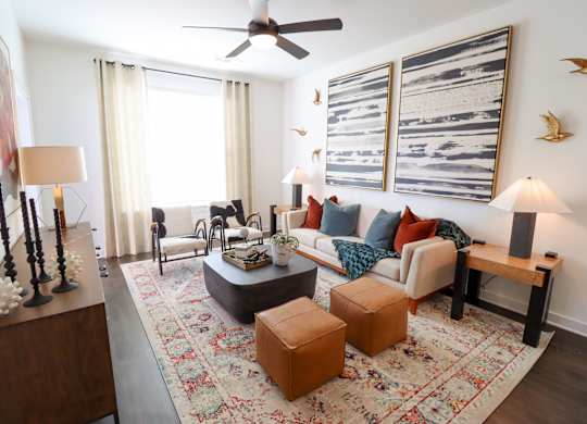 Living room with modern furniture and abstract artwork at The Wren Apartments, Lawrenceville, GA 30043