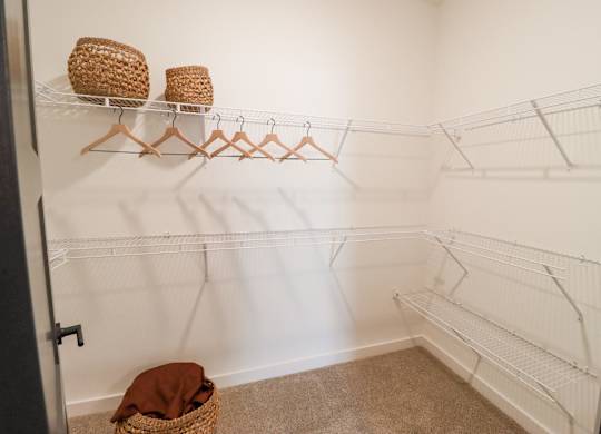 Walk-in closet with wire shelving and hangers at The Wren Apartments, Georgia, 30043