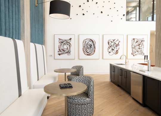 Lounge seating with abstract wall art and kitchenette at The Wren Apartments, Lawrenceville, Georgia
