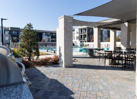 Outdoor patio with pergola and poolside dining at The Wren Apartments, Lawrenceville, 30043