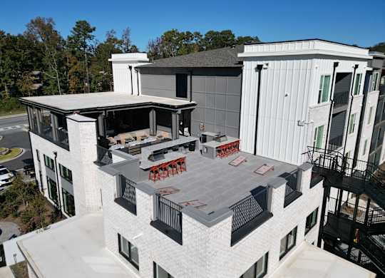 Rooftop terrace with outdoor kitchen and lounge seating at The Wren Apartments, Georgia