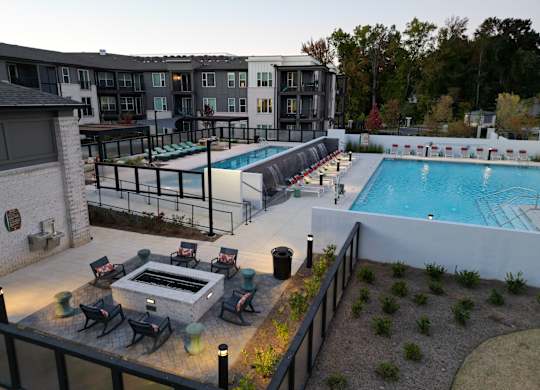 Outdoor pool deck with fire pit and lounge seating at The Wren Apartments, Lawrenceville, GA