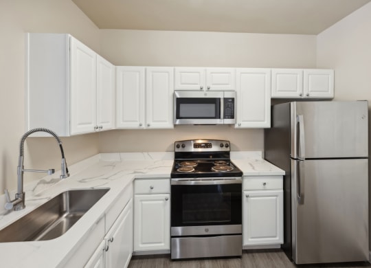 spacious kitchen with white cabinets and stainless steel appliances at Bridgeport Ranch apartments