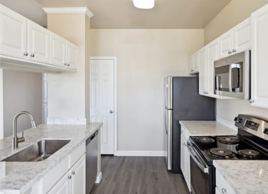 spacious kitchen with white cabinets and stainless steel appliances at Bridgeport Ranch apartments