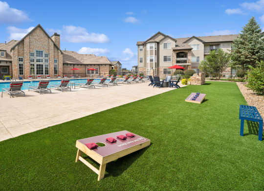 lawn with cornhole games at Red Hawk Ranch apartments