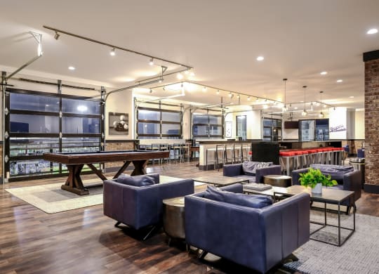a lounge area with couches and tables and a pool table