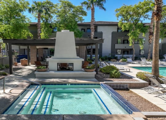 poolside covered lounging area with a fireplace at Avora apartments