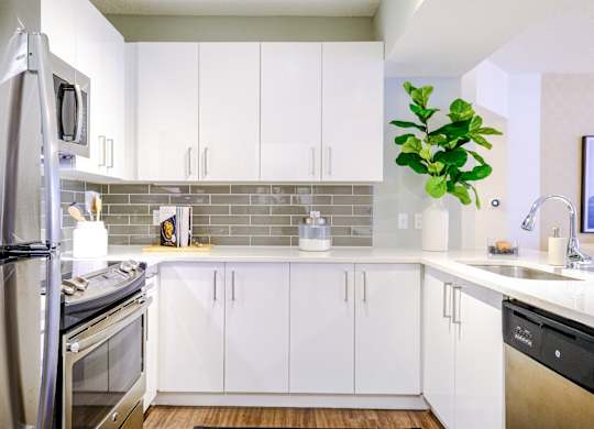 Kitchen with custom white cabinetry and stainless appliances at Sophia at Abacoa luxury Jupiter, FL apartments