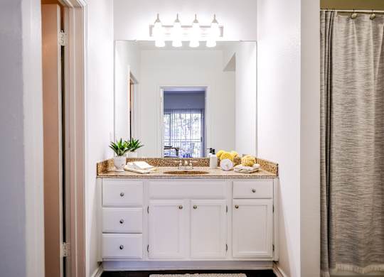 luxury bathroom vanity with custom cabinetry and designer lighting at San Marin apartments