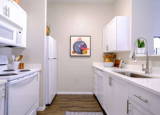 luxury kitchen with modern white cabinetry and gleaming countertops at Roosevelt Square apartments
