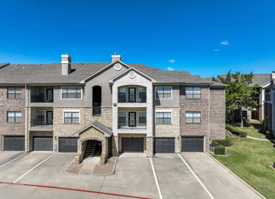 exterior view of Stoneleigh on Spring Creek apartments with garages in Garland, TX