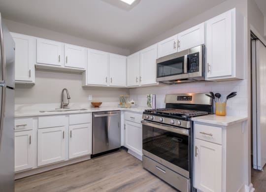 Heathermoor and Bedford Commons apartments kitchen with white cabinets and stainless appliances