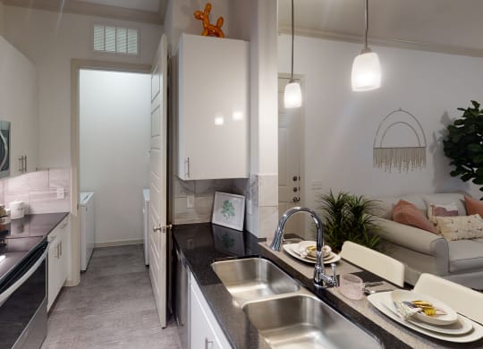 a kitchen with white cabinets and black countertops