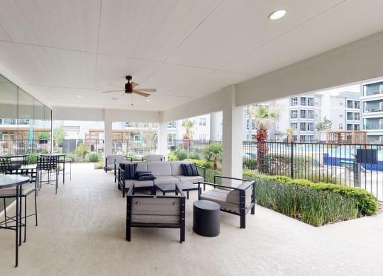 a patio with couches and chairs and a ceiling fan