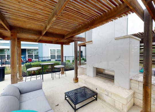 a patio with a fireplace and a pergola