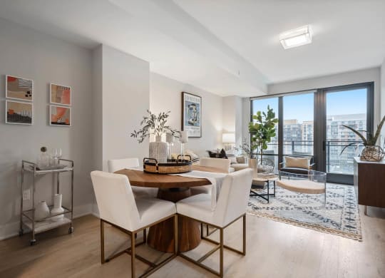A dining room with a table and chairs and a large window at Tribeca NOMA apartments