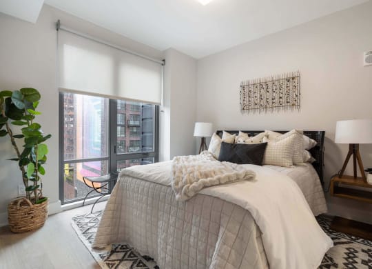 a bedroom with a large window view at Tribeca NOMA apartments