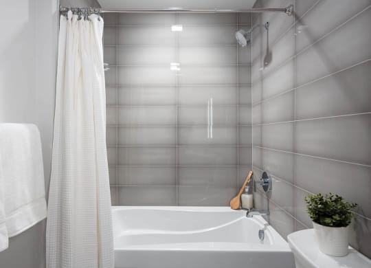 a bathroom with a bathtub shower and sink in Tribeca NOMA apartments