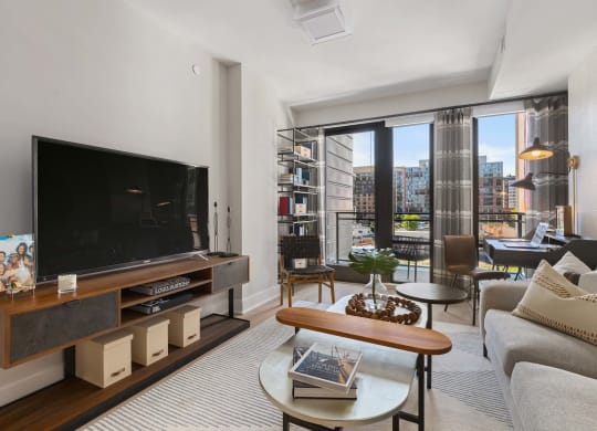 a living room with large windows and a balcony at Tribeca NOMA apartments