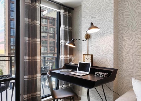 A work from home space with a desk and large window at Tribeca NOMA apartments