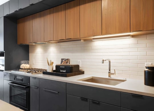 a white kitchen with wooden cabinets at Tribeca NOMA apartments
