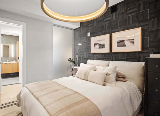 a bedroom and bathroom with circular light fixture at Tribeca NOMA apartments