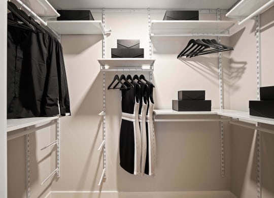 a walk in closet with white walls and white shelves at Tribeca NOMA apartments