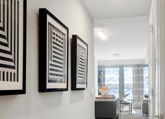 a hallway with art on the wall and a door to a living room at Tribeca NOMA apartments