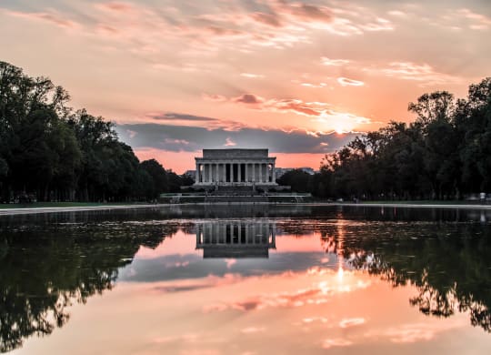 a sunset over the reflecting pool at the memorial
