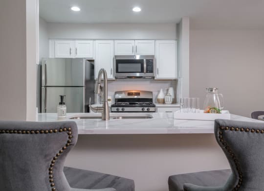The Residence at Christopher Wren apartments kitchen with stainless appliances and white cabinetry