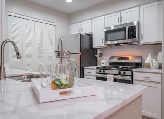 kitchen with stainless appliances and white cabinetry at The Residence at Christopher Wren apartments