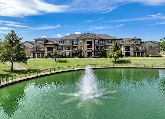 the lake with a fountain at The Falls at Copper Lake apartments
