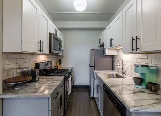 The Edison apartments kitchen with stainless appliances and white cabinetry