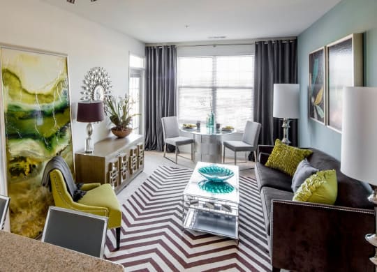 a living room with a couch table and large window at Reveal Hackensack apartments