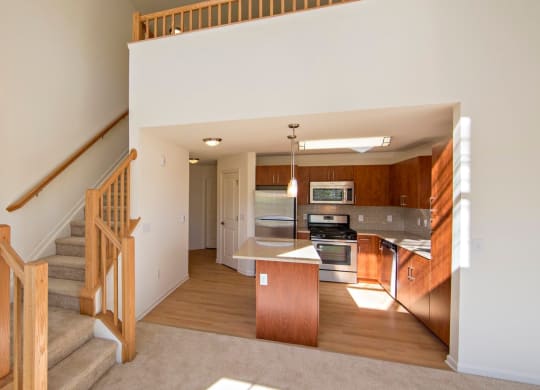 a kitchen and staircase to a second floor at Reveal Hackensack apartments