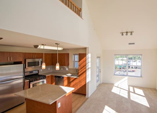 a kitchen and living room with a large window at Reveal Hackensack apartments