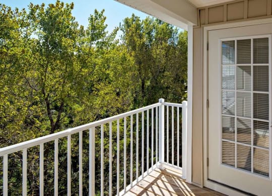 a door on the deck of a unit with trees at Reveal Hackensack apartments