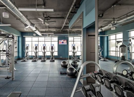 a gym with weights and other exercise equipment at Reveal Hackensack apartments